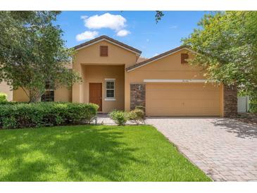 Charming single-story home with a well-manicured lawn, a two-car garage, and neutral-colored exterior paint at 9110 Stromboli Ct, Kissimmee, FL 34747