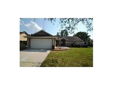 Charming single-story home features an attached two-car garage and well-maintained front lawn at 1128 Lyric Dr, Deltona, FL 32738