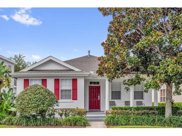Charming single-story home featuring a red front door, decorative shutters, and a well-maintained landscaped yard at 7416 Soiree Way, Reunion, FL 34747