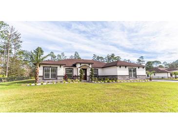 Charming single-story home with well-manicured lawn and lush landscaping creating great curb appeal at 18623 Tunbridge St, Orlando, FL 32833