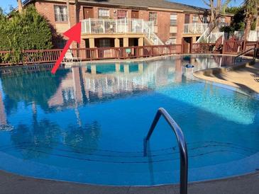 Community pool view of the apartments featuring well-maintained landscaping and blue water at 2525 Caper Ln # 205, Maitland, FL 32751