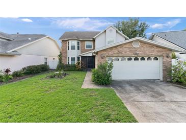 Charming two-story home with brick accents, attached garage, and a well-maintained lawn at 3310 Tall Timber Dr, Orlando, FL 32812
