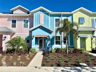 Colorful townhomes featuring manicured landscaping and charming pastel exteriors on a sunny day at 3117 Caribbean Soul Dr, Kissimmee, FL 34747