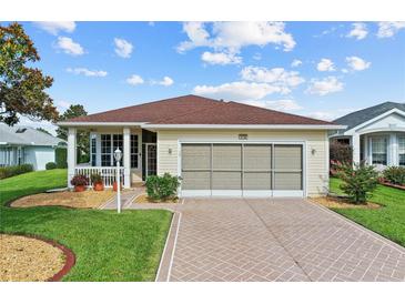 Charming single-story home with a well-manicured lawn, brick driveway, and a lovely screened-in garage at 4738 St Andrews Arc, Leesburg, FL 34748