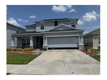 Charming two-story home with stone accents, well-manicured lawn, and spacious driveway at 564 Meadow Bend Dr, Davenport, FL 33837
