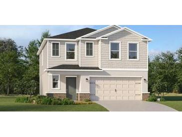 Charming two-story home with a symmetrical facade, a two-car garage and a well-manicured lawn at 4389 River Beacon Blvd, Davenport, FL 33837