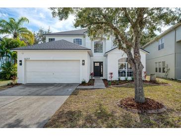 Charming two-story home boasts an attached two-car garage and a well-manicured front yard at 14217 Sapphire Bay Cir, Orlando, FL 32828