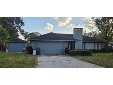 Charming single story home featuring an attached two-car garage and lush green lawn at 1405 Ridgegreen N Loop, Lakeland, FL 33809