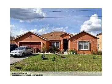 Charming single-story home with well-maintained lawn and two-car garage at 675 Elbridge Dr, Kissimmee, FL 34758
