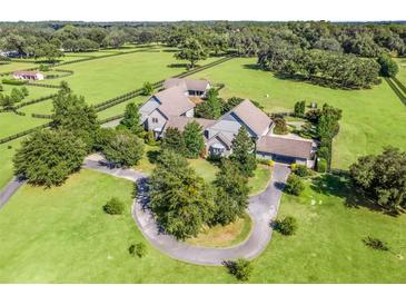 Stunning aerial view of the estate with manicured lawns and a circular driveway leading to the luxurious home at 10621 Sw 11Th Ter, Ocala, FL 34476
