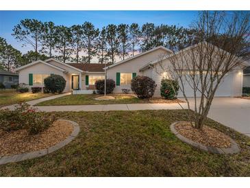 Charming single-story home with landscaped front yard, green shutters and a well-manicured lawn at 8447 Se 137Th Loop, Summerfield, FL 34491