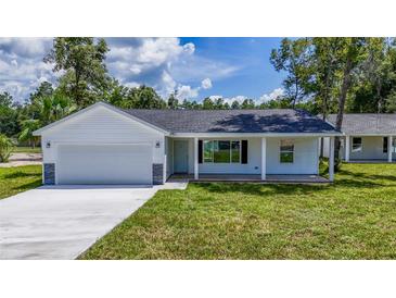 Newly built home with a covered porch and a gray stone accent at 13026 Ne 6 Pl, Silver Springs, FL 34488