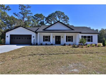 White farmhouse exterior with black accents and a spacious lawn at Tbd W C 466 # Lot 1, Oxford, FL 34484