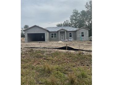 New construction home with attached garage and neutral color scheme at 12757 Se 104Th Ter, Belleview, FL 34420