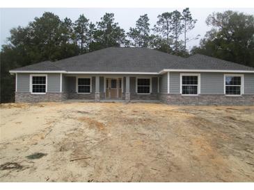 Charming single-story home showcasing stone accents and a symmetrical front facade at 13083 Sw 61St Place Rd, Ocala, FL 34481