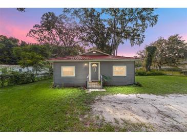 Gray house with red roof, steps, and grassy yard at 3331 Se 11Th Ave, Ocala, FL 34471