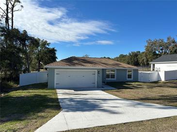 Newly constructed home with a white vinyl fence and a two-car garage at 1696 Sw 144Th Ct, Ocala, FL 34481