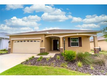 Charming single-story home with a two-car garage, landscaped front yard, and covered entryway at 9994 Sw 96Th St, Ocala, FL 34481