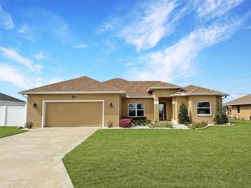 Charming single-story home featuring a well-manicured lawn and an attached two-car garage at 10200 Se 67Th Ter, Belleview, FL 34420