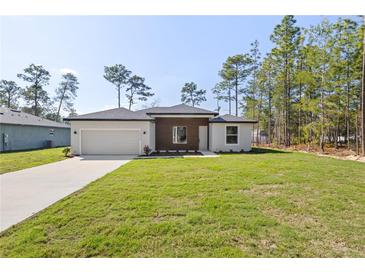 New construction home with manicured lawn, a two-car garage, and inviting front entrance at 13374 Sw 63Rd Ter, Ocala, FL 34473