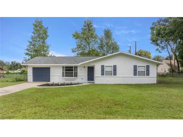 Newly renovated home with a freshly painted exterior and a well-maintained lawn at 5761 Ne 4Th Pl, Ocala, FL 34470