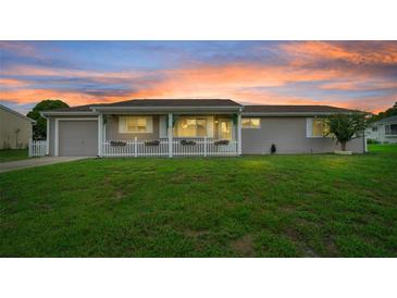 Charming single-story home with a well-manicured lawn and welcoming front porch at sunset at 10820 Sw 87Th Ter, Ocala, FL 34481