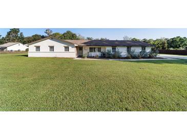 Charming single-story home with a well-manicured lawn and inviting front porch at 4011 Se 47Th Pl, Ocala, FL 34480