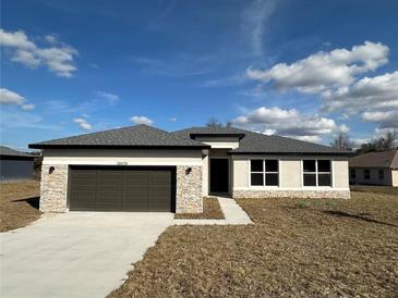 Charming single-story home with stone accents, gray roof, and two-car garage at 10131 Sw 41St Ave, Ocala, FL 34476