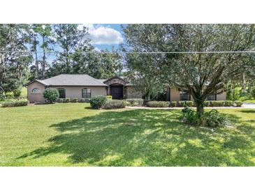 Single-story home with stone accents and landscaped yard at 5135 Nw 82Nd Ct, Ocala, FL 34482