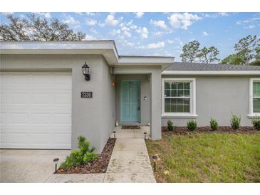 Charming single-story home with a well-maintained lawn and a bright, inviting turquoise front door at 7336 Sw 131St Ln, Ocala, FL 34473