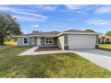 Newly constructed home with a two-car garage and well-manicured lawn at 19682 Sw 93Rd Ln, Dunnellon, FL 34432