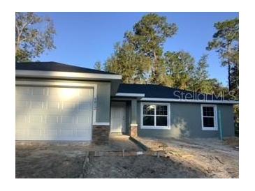 Newly constructed home with gray exterior and a two-car garage at 9812 Sw 196Th Avenue Rd, Dunnellon, FL 34432