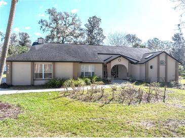 Lovely single-story home with an arched entryway, manicured lawn, and mature landscaping at 4215 Se 24Th Ter, Ocala, FL 34480