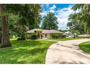 Traditional-style home with mature landscaping, a circular driveway, and inviting curb appeal at 4893 Sw 4Th Cir, Ocala, FL 34471