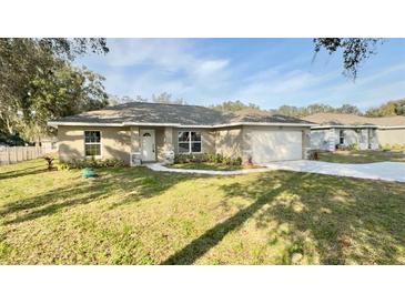 Charming one-story home with a well-manicured lawn, stone accents, and inviting curb appeal at 9285 Se Highway 42, Summerfield, FL 34491