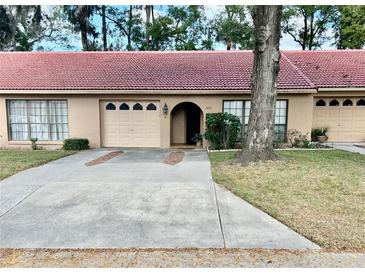 Charming one-story home with a concrete driveway, beige garage door, and a beautiful clay tile roof at 3457 Sw 18Th Pl, Ocala, FL 34474