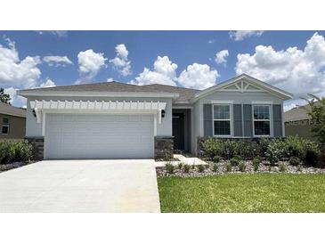Charming single-story home with a two-car garage, landscaped yard, and a well-manicured lawn at 9313 Sw 60Th Court Rd, Ocala, FL 34476