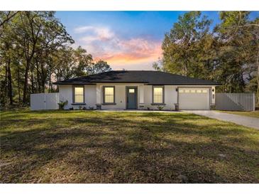 Newly constructed home showcasing a white exterior, gray door, and attached garage at 14152 Se 43Rd Ter, Summerfield, FL 34491