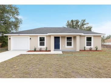 Charming single-story home showcasing a neutral color scheme, attached garage, and manicured front yard at 2815 Sw 147 Ter, Ocala, FL 34481