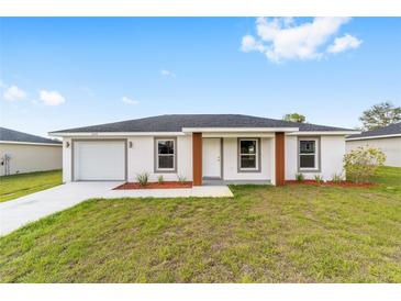 Charming single-story home with a well-manicured lawn, painted in a light color with grey trim at 3514 Sw 149 Ct, Ocala, FL 34481