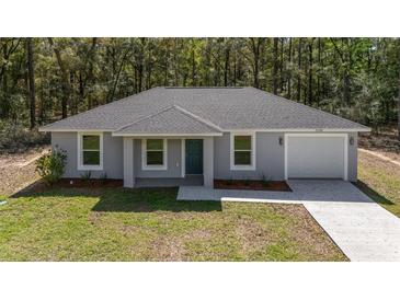 Charming single-story home featuring a gray exterior, well-manicured lawn, and an attached one car garage at 13237 Sw 114 Pl, Dunnellon, FL 34432