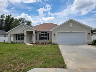 Charming single-story home featuring a well-maintained lawn, attached two-car garage, and neutral exterior paint at 11610 Sw 59Th Terrace, Ocala, FL 34476
