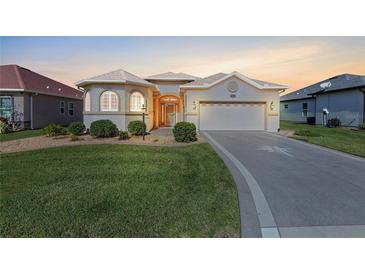 Charming single-story home featuring a well-manicured lawn and an attached two-car garage at 10927 Se 168Th Loop, Summerfield, FL 34491