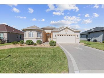 Charming single-story home featuring stucco exterior, manicured lawn, and a welcoming two-car garage at 10927 Se 168Th Loop, Summerfield, FL 34491