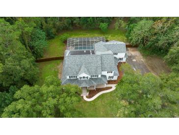 Aerial view of a two-story house with pool and lush landscaping at 2704 Se 31St St, Ocala, FL 34471