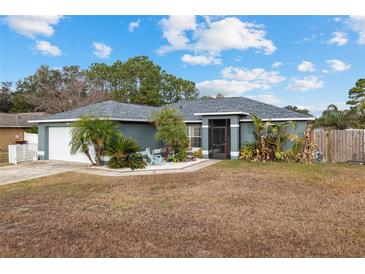 Single-story home with gray exterior, white garage door, and landscaping at 35 Teak Rd, Ocala, FL 34472