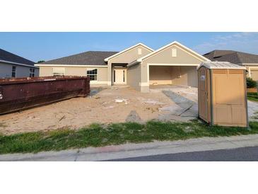 Exterior view of home with gray paint, showing construction debris in the yard at 8357 Sw 58Th Ave, Ocala, FL 34476