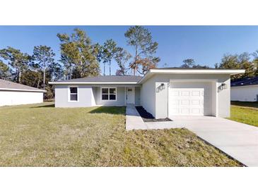 Newly constructed home with a one-car garage and a well-manicured lawn at 232 Locust Pass, Ocala, FL 34472