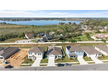 An aerial view of a newly constructed community featuring stunning water views and modern homes at 547 Tanaro Ln, Haines City, FL 33844