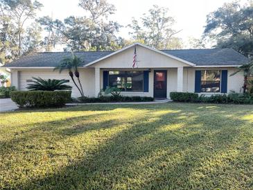 One-story house with white brick exterior, blue shutters, and a well-maintained lawn at 12467 Se 62Nd Ave, Belleview, FL 34420